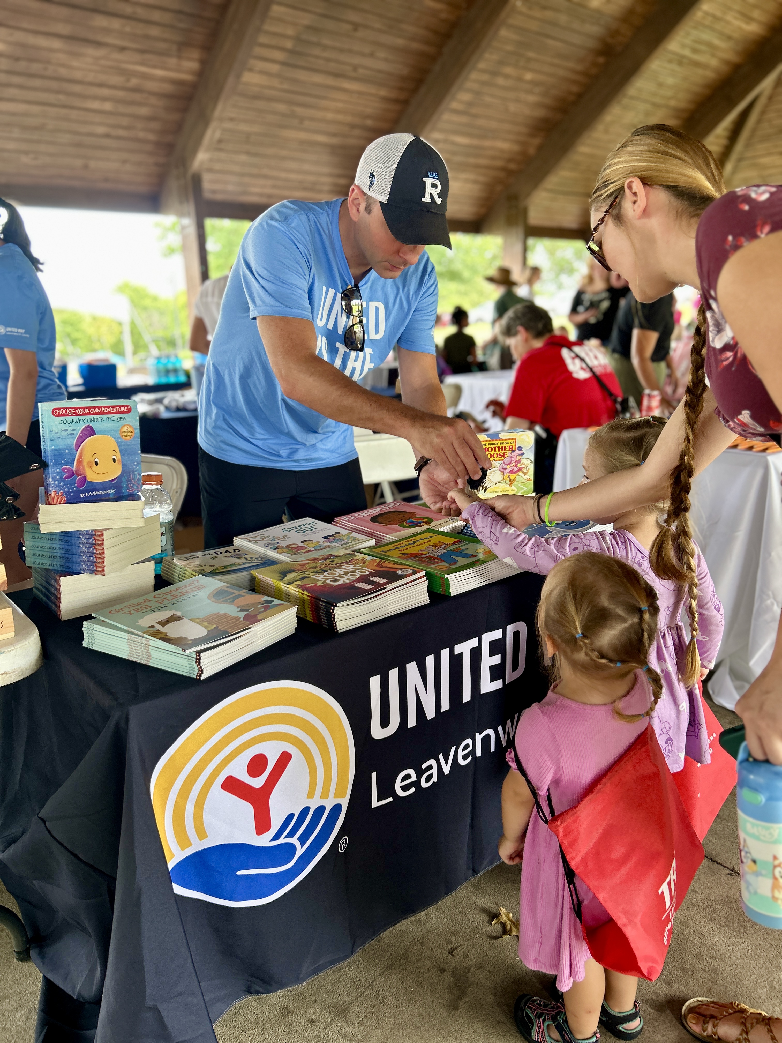 Providing a book to a child.